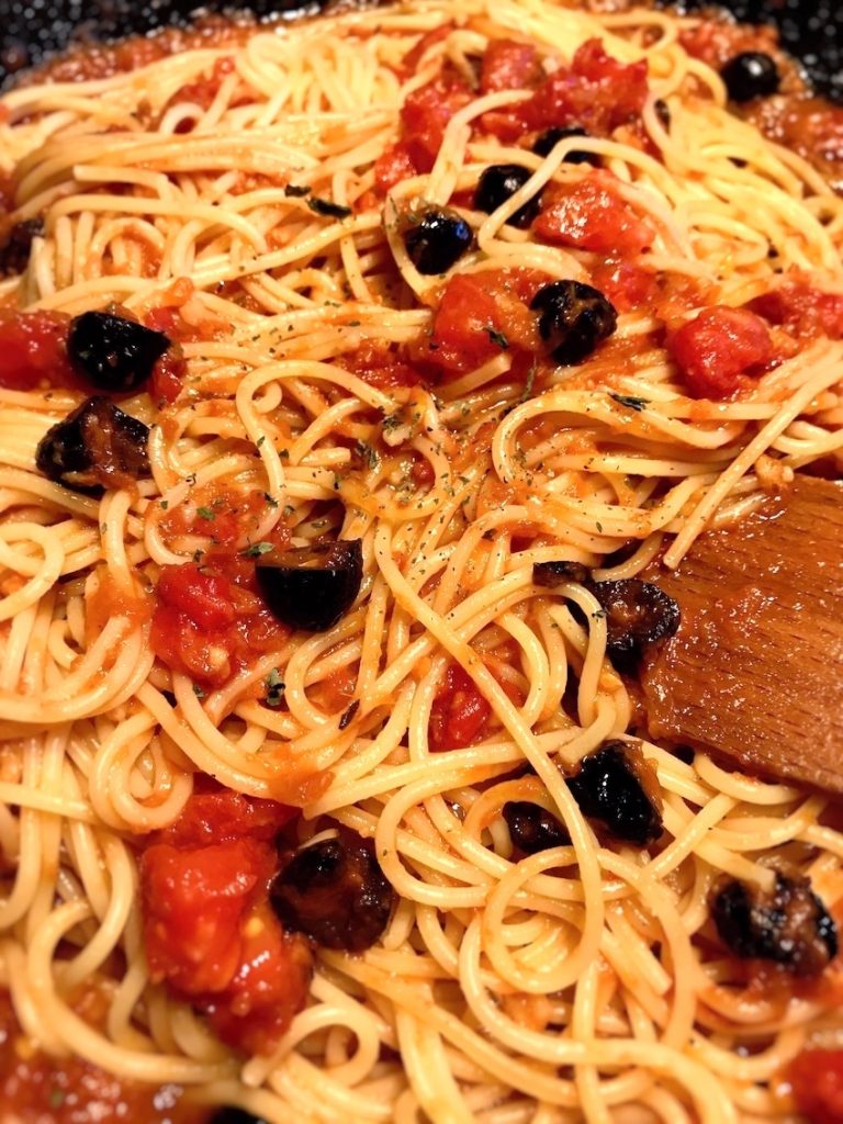 Spaghetti und Oliven hinzugeben
